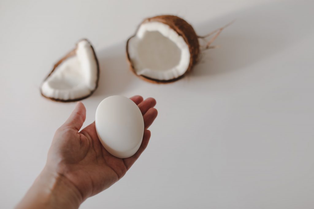 Coconut Empire HQ hand with natural coconut soap shampoo bar white background min